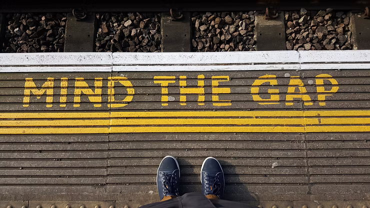 Mind the gap sign on floor of train station